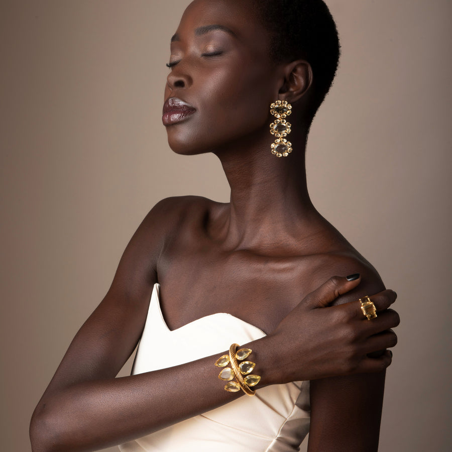 Woman wearing gold jewelry against a neutral background