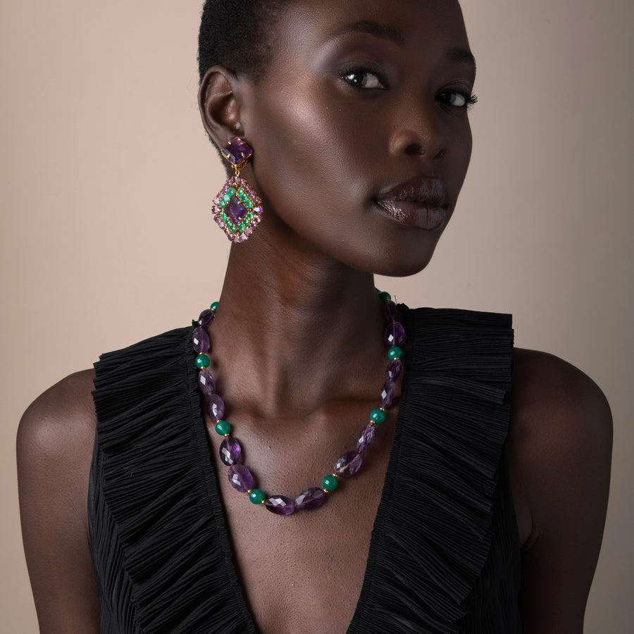 Woman wearing a necklace and earrings on a beige background