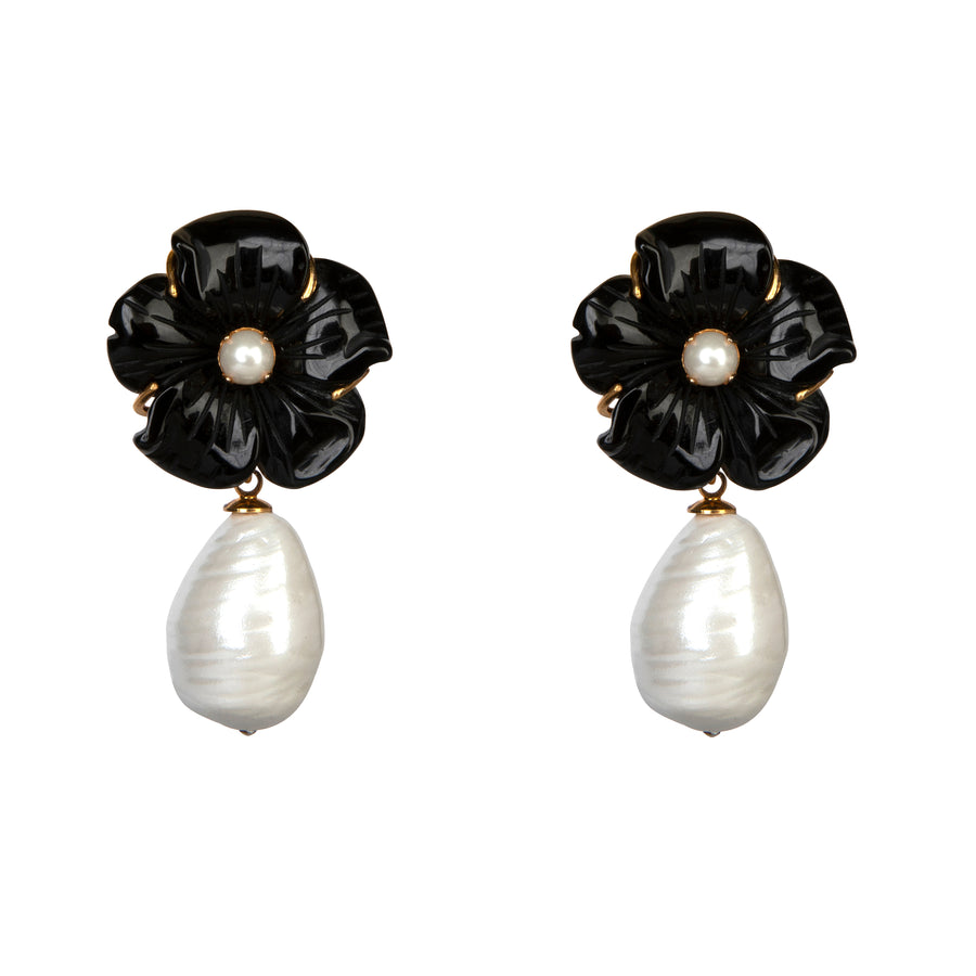 Pair of earrings with black flower designs and white pearl drops on a white background