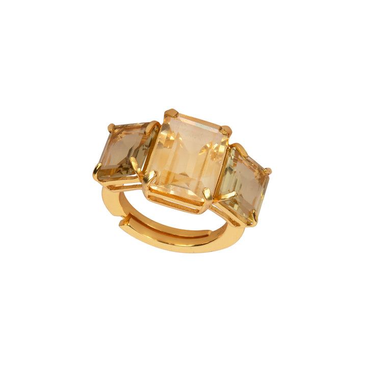 Gold ring with three square-cut gemstones on a white background