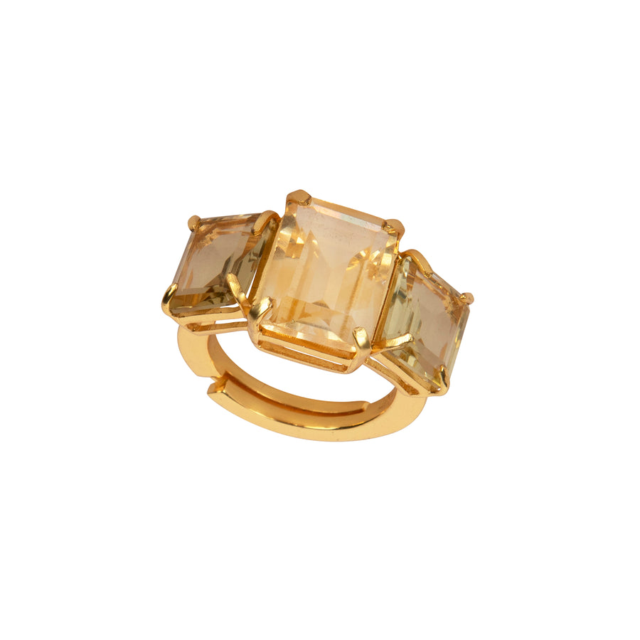 Gold ring with three square-cut gemstones on a white background
