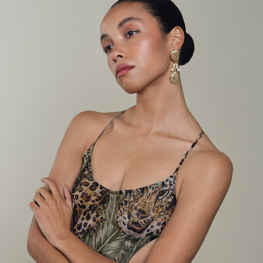 Woman wearing a leopard print top with a neutral background