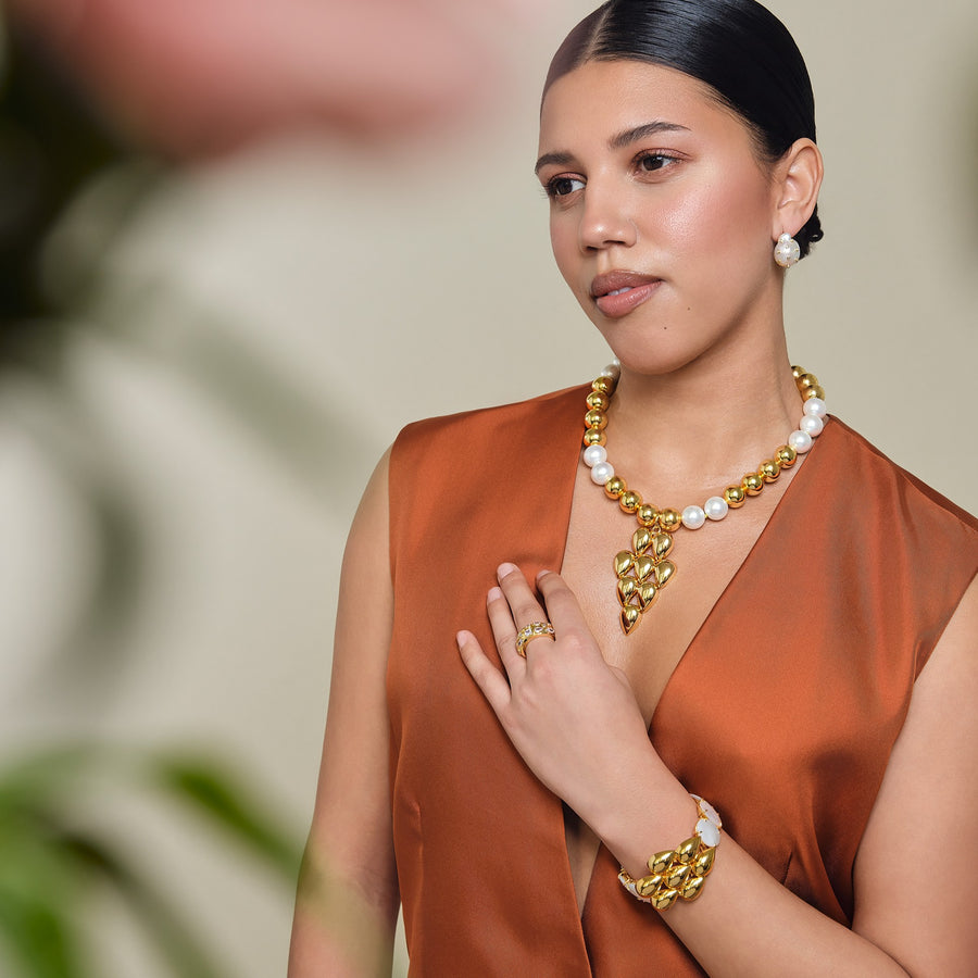 Woman wearing gold jewelry with a blurred background